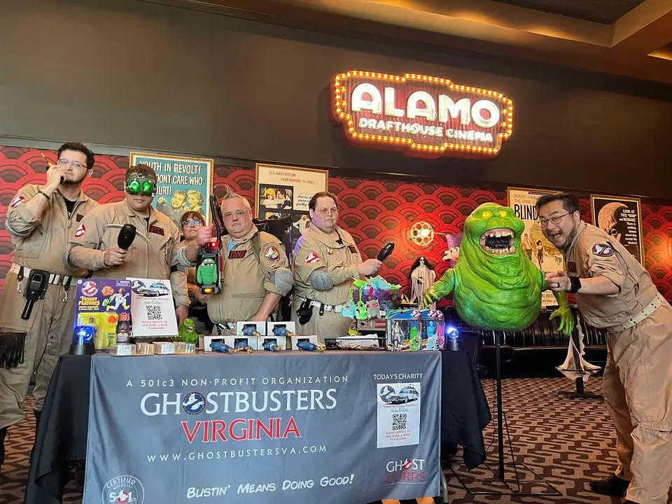 Ghostbusters Virginia members at an Alamo Drafthouse Cinema event with Slimer prop and franchise banner