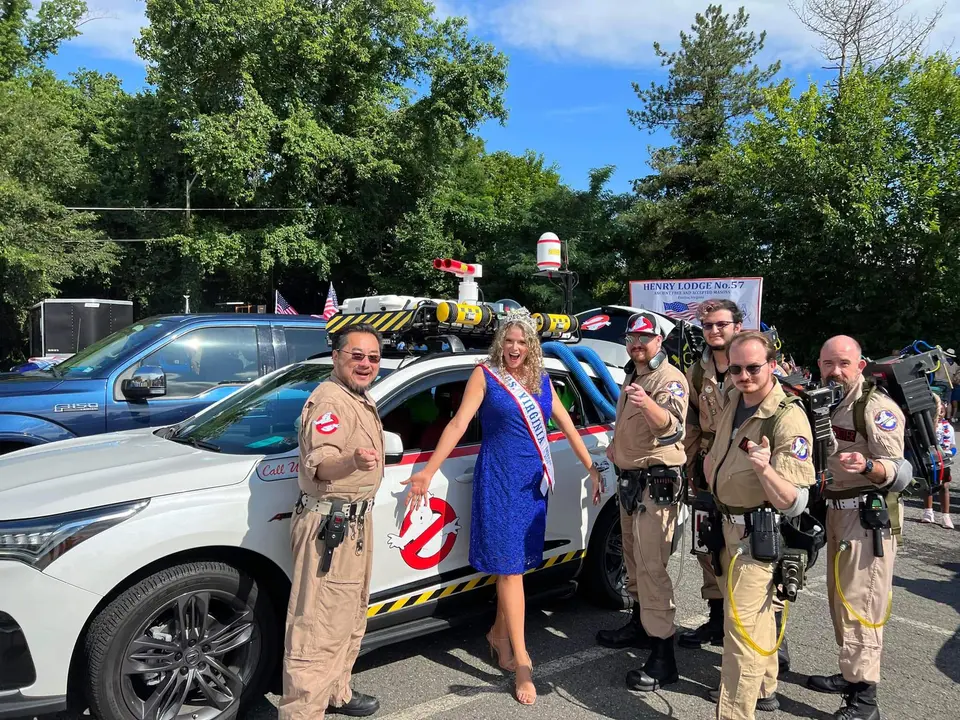 Ghostbusters Virginia members posing with a pageant winner next to the Ecto vehicle