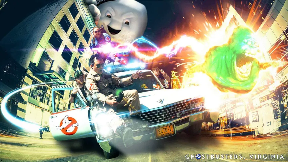 Two Ghostbusters Virginia members posing with a Slimer prop and Stay Puft Marshmallow Man background
